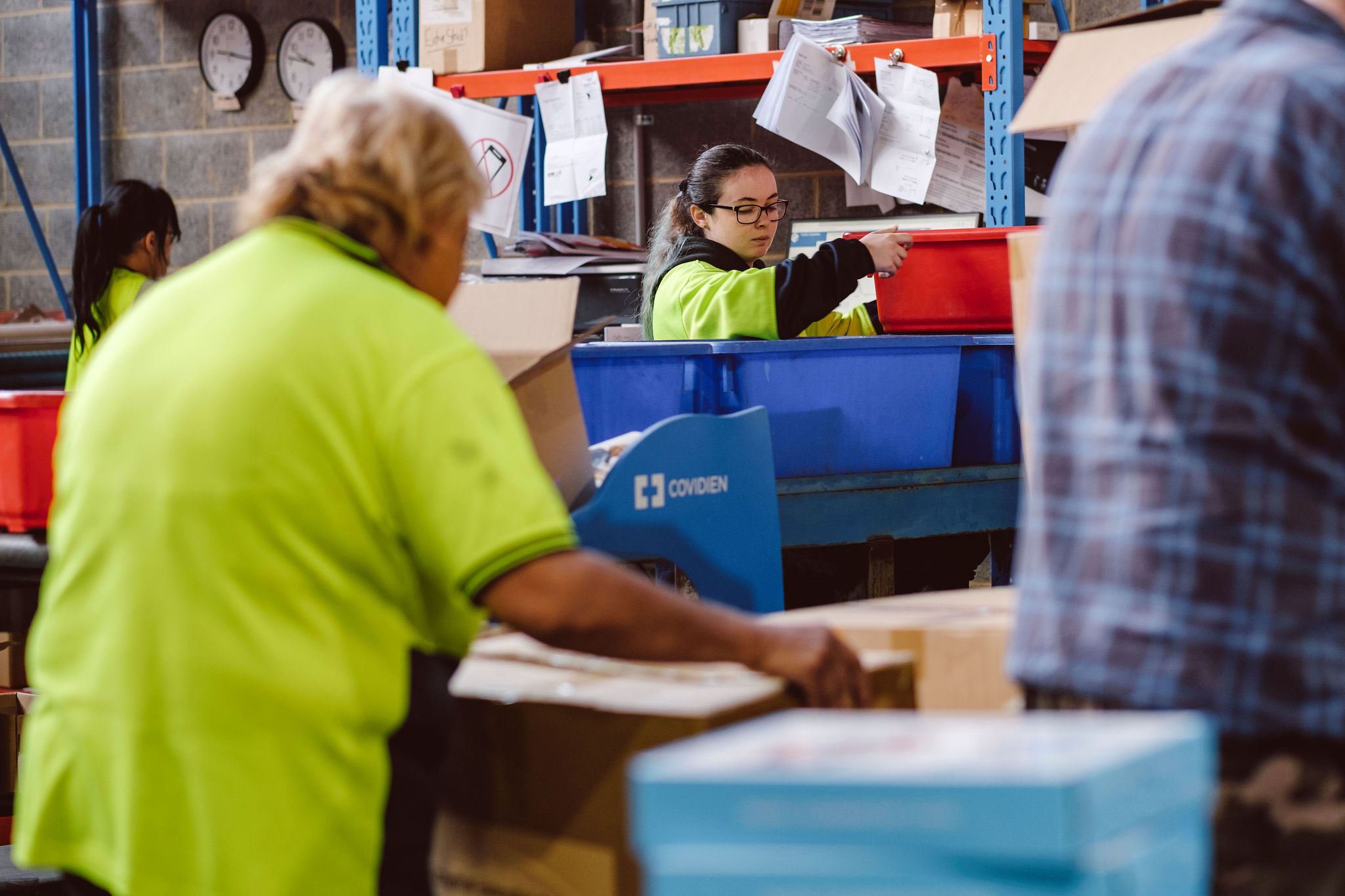 workers in hi-vis picking and packing boxes