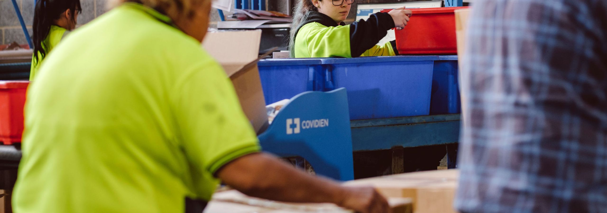workers in hi-vis picking and packing boxes