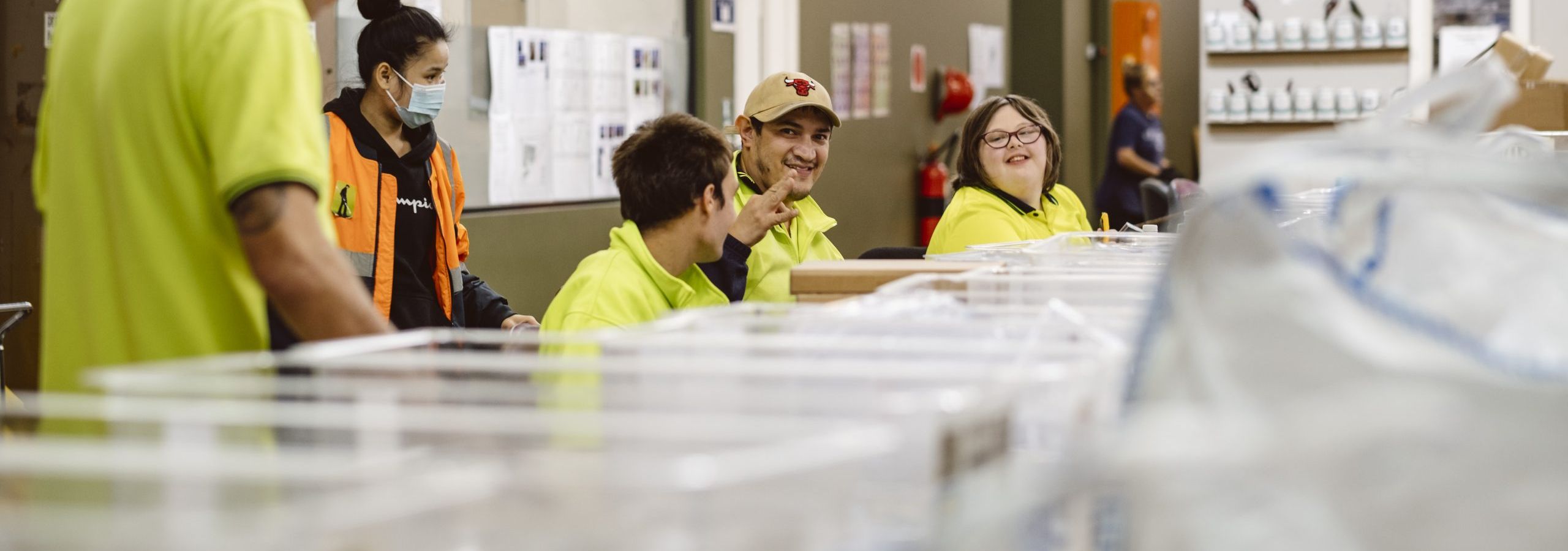 employees in high visibility uniform smiling while at work in a supported employment environment