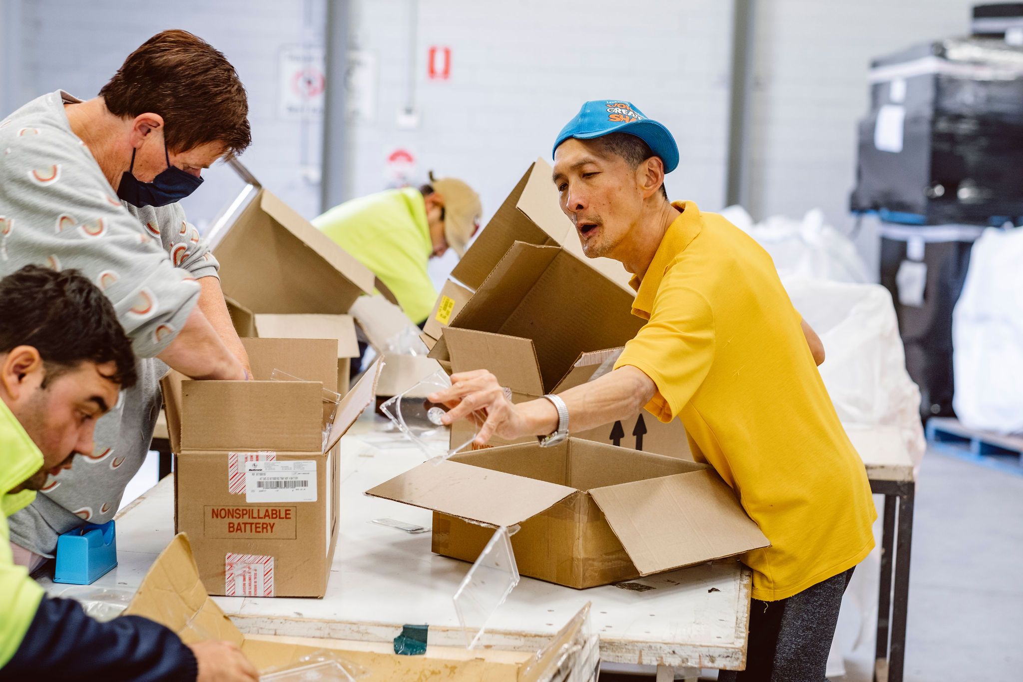 employees emptying boxes and placing products to be destroyed onto conveyer